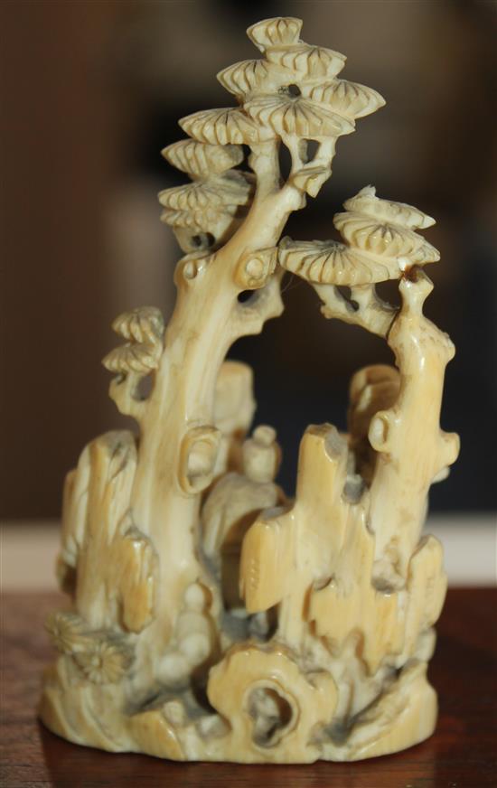 A Chinese ivory group of scholars playing weiqi beneath a pine tree, 19th century, 8.7cm, wood stand, slight repair